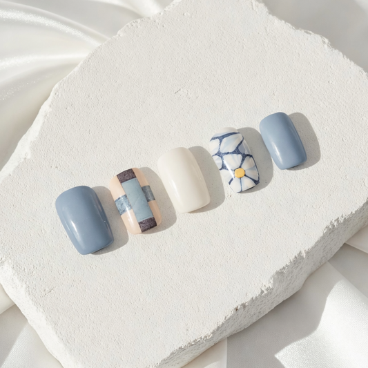 Blue and grey press-on nails featuring a delicate mosaic flower design.