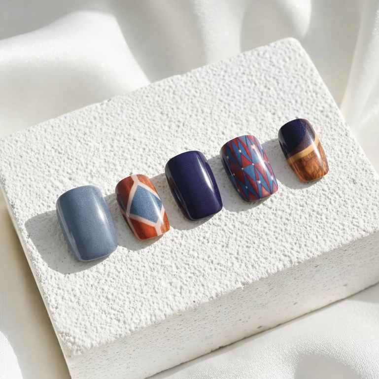 Elegant press-on nails with geometric blue and red patterns.