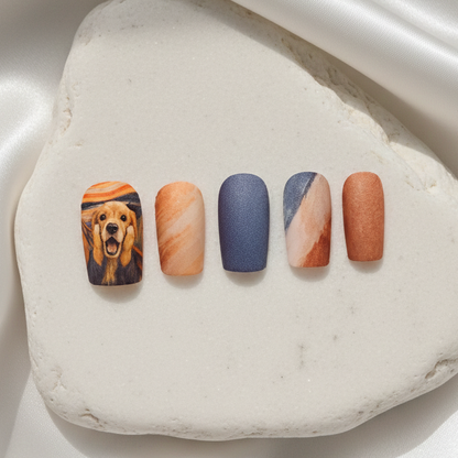Press-on nail set with a golden retriever styled after The Scream, alongside warm-toned marble and matte brown accents.